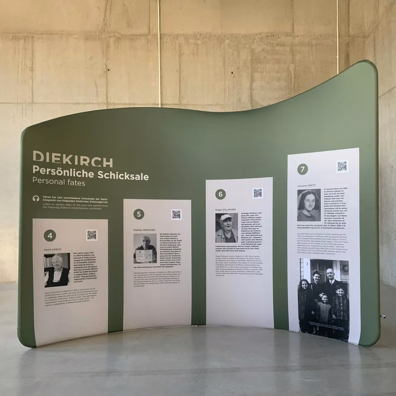Geschwungene Ausstellungswand mit Bildern und Texten
