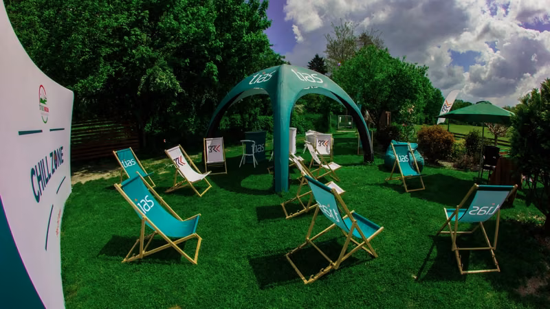 Liegestühle und Eventzelt mit Branding im Garten